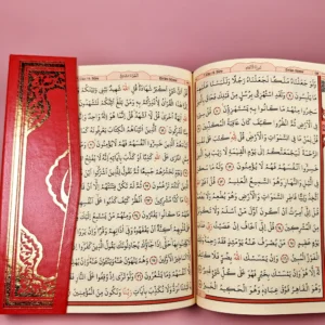 Coran rouge clair ouvert, texte en arabe