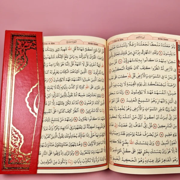 Coran rouge clair ouvert, texte en arabe